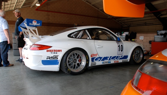 White & blue striped TruSpeed Porsche GT3 cup car #10_garage 2_3/4 rear view_California Festival of Speed_April 6, 2013